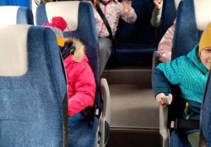Zadowolone przedszkolaki podczas jazdy busem do kina.