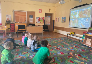 Dzieci oglądają prezentacje multimedialne związane z tematyką Wiosenną