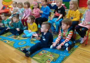 Dzieci słuchają Teatrzyku KAMISHIBAI