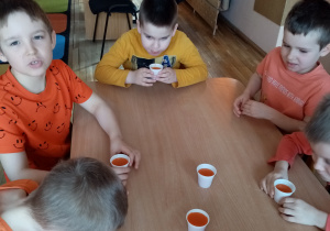Przedszkolaki degustują sok marchewkowy.