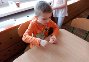 Chłopiec degustuje surówkę z marchewki.