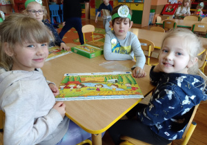 Dzieci pokazują ułożone puzzle o tematyce ekologicznej