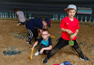 Chłopcy odkopują szkielet dinozaura.