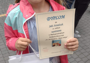 Julia prezentuje dyplom za zdobycie wyróżnienia w konkursie.