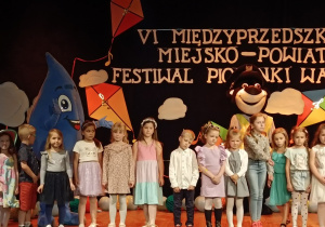 Grupa dzieci stoi na scenie