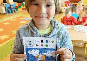 Chłopiec pokazuje swój pokolorowany obrazek.