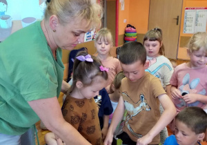 Dzieci rozpuszczają czekoladę w kąpieli wodnej.
