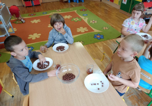 Dzieci jedzą czekoladowe kulki.