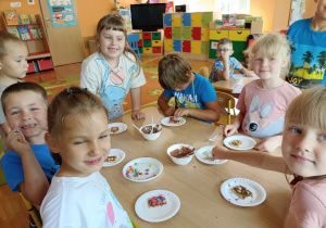 Dzieci z grupy 3 zdobią ciasteczka płynną czekoladą i kolorowymi cukiereczkami