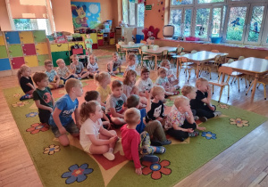 Dzieci siedząc na dywanie oglądają bajkę o emocjach