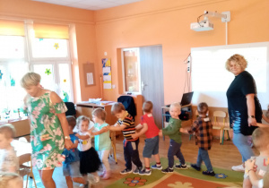 Dzieci z grupy II wraz z nauczycielkami tańczą tworząc pociąg.