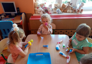 Dziewczynki bawią się przy stoliku.