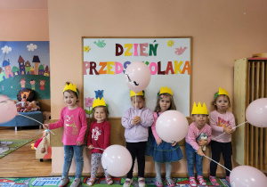 Dziewczynki z grupy najmłodszej stoją na tle tablicy Dzień Przedszkolaka.