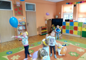 Dzieci bawią się balonami podrzucając je.