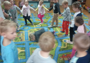 Przedszkolaki tańczą w kole.
