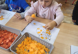 Dzieci wyklejają kolorowym papierem obrazki zwierząt.