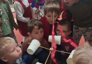 Dzieci robią wiatromierz z plastikowych kubeczków.
