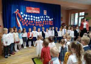 Przedszkolaki wraz z nauczycielkami śpiewają hymn.