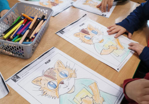 Dzieci kolorują obrazek przedstawiający kota Amadeusza.