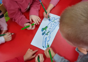 Dzieci kolorują obrazek przedstawiający krokodyla.
