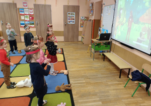 Dzieci naśladują ruchy misia z dużego ekranu