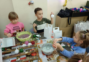 Dzieci samodzielnie ozdabiają bombki brokatami