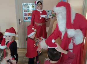 Mikołaj podaje rękę dzieciom.