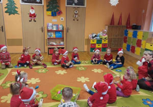 Przedszkolaki grają dla Św. Mikołaja na instrumentach.