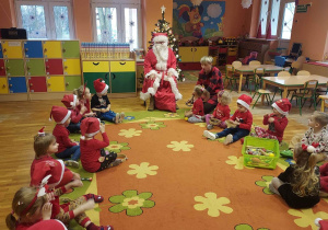 Dzieci siedzą w kole, Mikołaj rozmawia z dziećmi.
