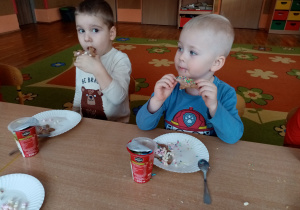 Chłopcy jedzą udekorowane pierniki.