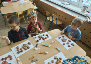 Dzieci ozdabiają cukierniczymi pisakami pierniki
