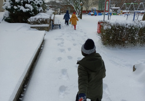 Dzieci biegną po śniegu