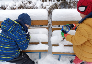 Dzieci oglądają śnieg przez lupy