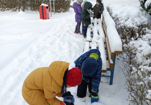 Dzieci oglądają śnieg przez lupy