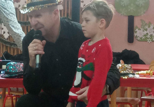 Pan Maciej zaprosił na scenę chłopca i opowiada dzieciom historię saksofonu.
