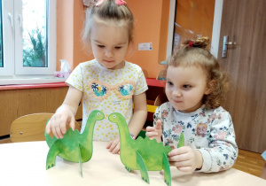 Dziewczynki bawią się dinozaurami.