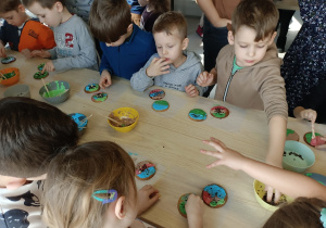 Dzieci zdobią kolorowymi lukrami ciastka