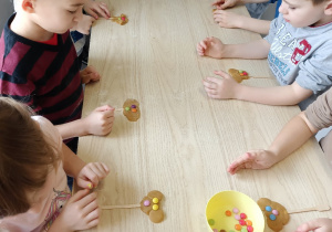Dzieci robią ciastka w kształcie misia na patyku