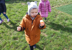 Chłopiec pokazuje znalezione jajko.
