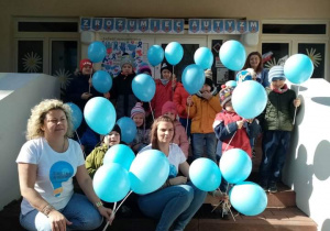 Grupa integracyjna z niebieskimi balonami.