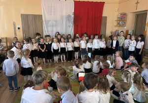 Grupa dzieci na tle flagi biało-czerwonej