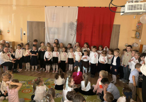 Grupa dzieci na tle flagi biało-czerwonej