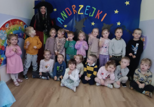 Zdjęcie grupowe dzieci na tle z napisem Andrzejki.