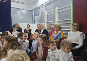 Dorośli i dzieci obserwują przedstawienie