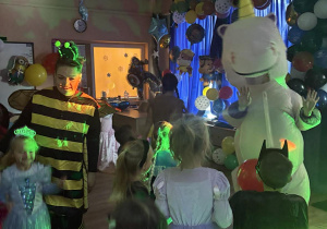 Bal karnawałowy. Dzieci w bajkowych przebraniach tańczą.