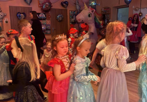 Bal karnawałowy. Dzieci w bajkowych przebraniach tańczą.