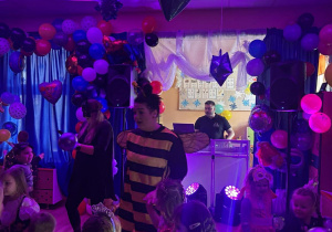 Bal karnawałowy. Dzieci w bajkowych przebraniach tańczą.