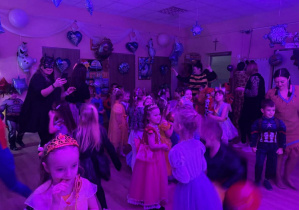 Bal karnawałowy. Dzieci w bajkowych przebraniach tańczą.