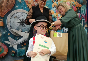 Na pierwszym planie jeden z uczestników konkursu, w tle dyrektorka i organizatorka konkursu