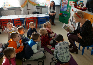 Przedszkolaki słuchają opowiadania czytanego przez Panią Dorotę.